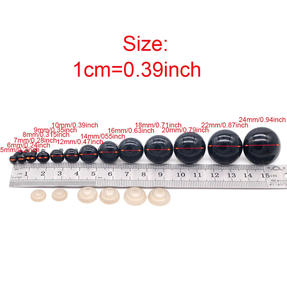 A row of black plastic safety eyes for amigurumi with locking washers shown next to a ruler.
