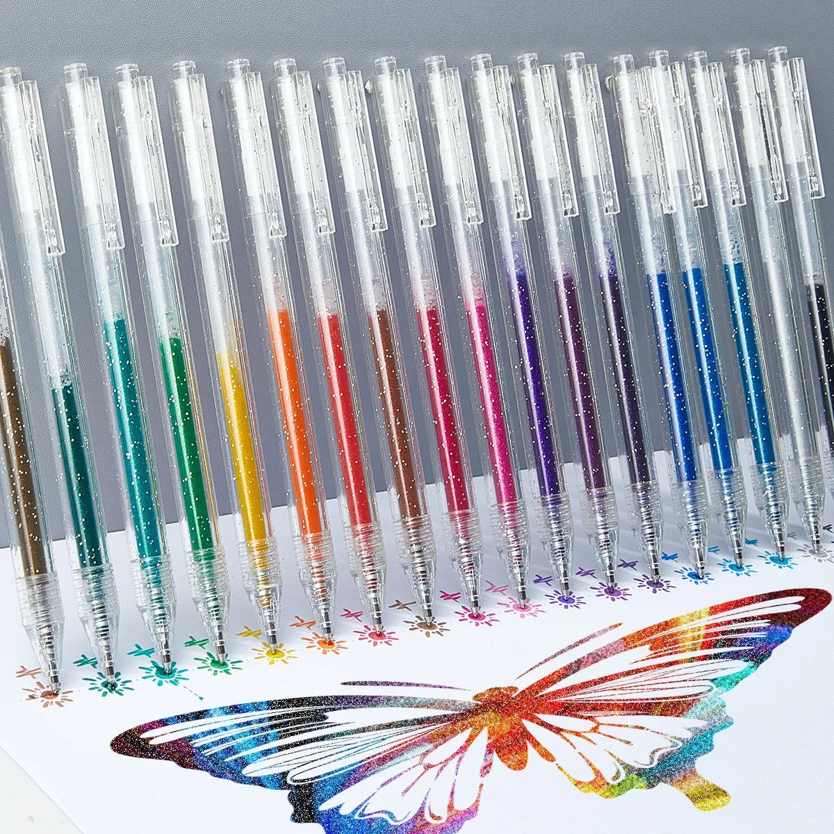 A collection of glitter gel pens in various colors arranged in a row, with a colorful butterfly design below.