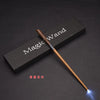 A brown magic wand with an LED light tip rests on a dark rectangular box.