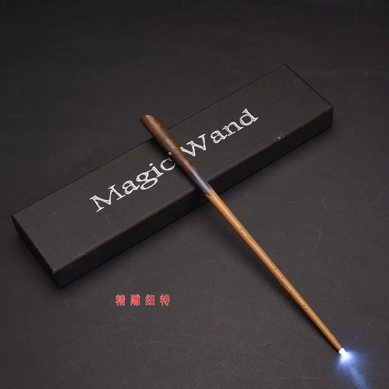 A brown magic wand with an LED light tip rests on a dark rectangular box.