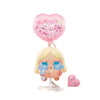 A vinyl figure of a blonde girl with teary eyes and a pink heart-shaped bubble above her.