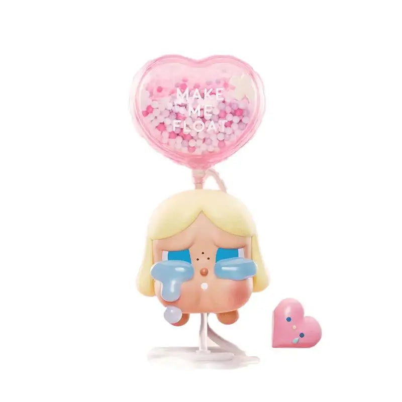 A vinyl figure of a blonde girl with teary eyes and a pink heart-shaped bubble above her.