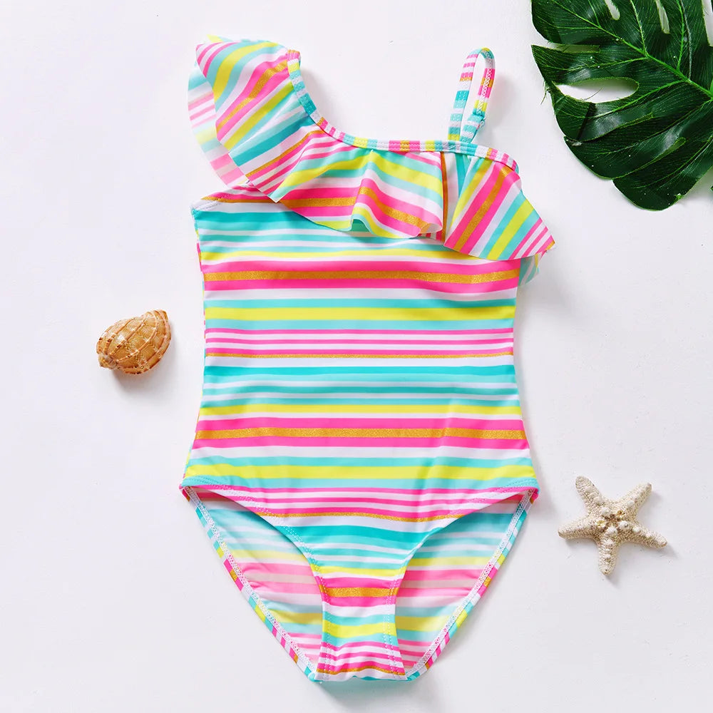 A vibrant striped one-piece swimsuit featuring pink, yellow, and blue colors with ruffled trim.