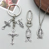 Silver antique cross charms and pendants for jewelry making displayed on a light gray surface.