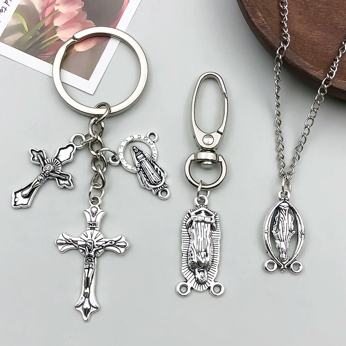 Silver antique cross charms and pendants for jewelry making displayed on a light gray surface.