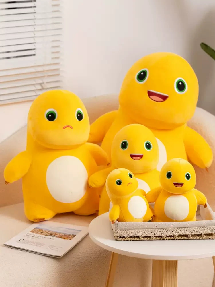 A yellow Kawaii Milk Dragon plush toy sitting on a white surface next to a small stuffed animal.