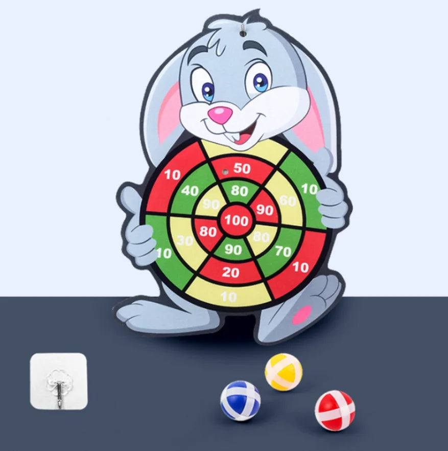 A cartoon gray rabbit holding a dartboard with colored targets and several small balls on a dark surface.