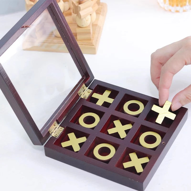 A wooden tic tac toe strategy game box with a glass lid and ten wooden tiles on a white surface.