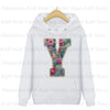 White hoodie featuring a large embroidered floral letter Y design on the chest