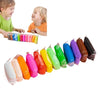 Three smiling children holding and interacting with a set of colorful air dry clay modeling tools and pieces.