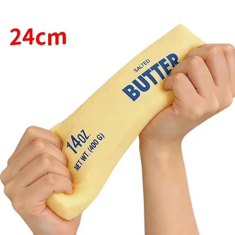 A hand is holding a yellow squishy butter stick fidget toy labeled salted butter with a 24cm length.