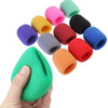 A hand holds a multi-pack of colorful microphone windscreen foam covers.