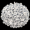 A pile of small white acrylic alphabet letter beads for jewelry making