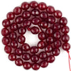 A cluster of deep red jasper and turquoise beads arranged in a circular pattern for jewelry making