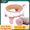 A pink manual knitting machine for making hats and scarves, with yarn balls nearby.
