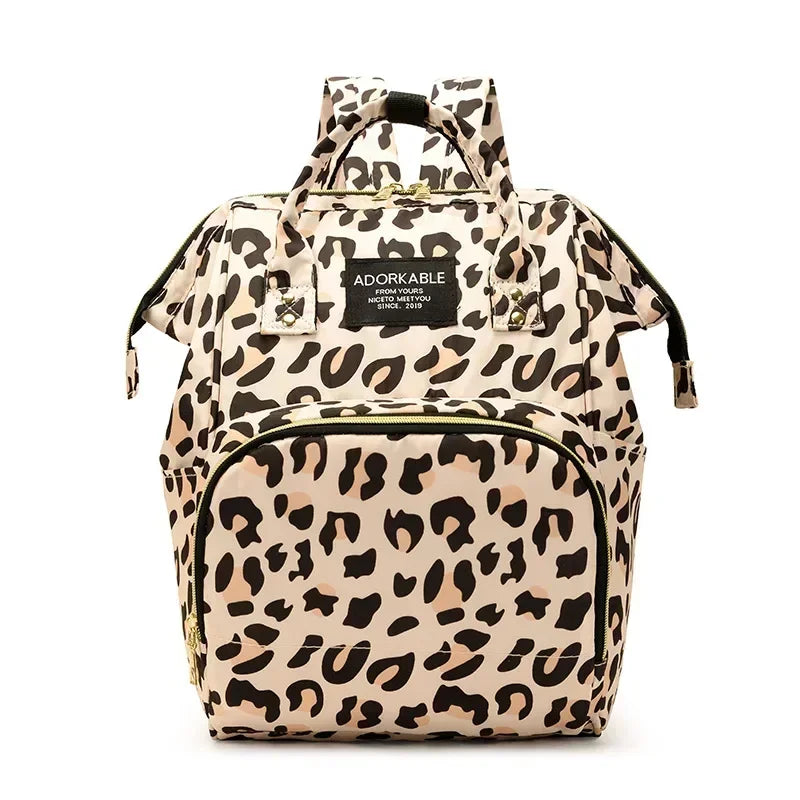 A beige and black leopard print waterproof diaper bag with a handle and multiple compartments.