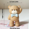 A standing bear figure with a bow, measuring 8.8cm tall and 6.1cm wide.