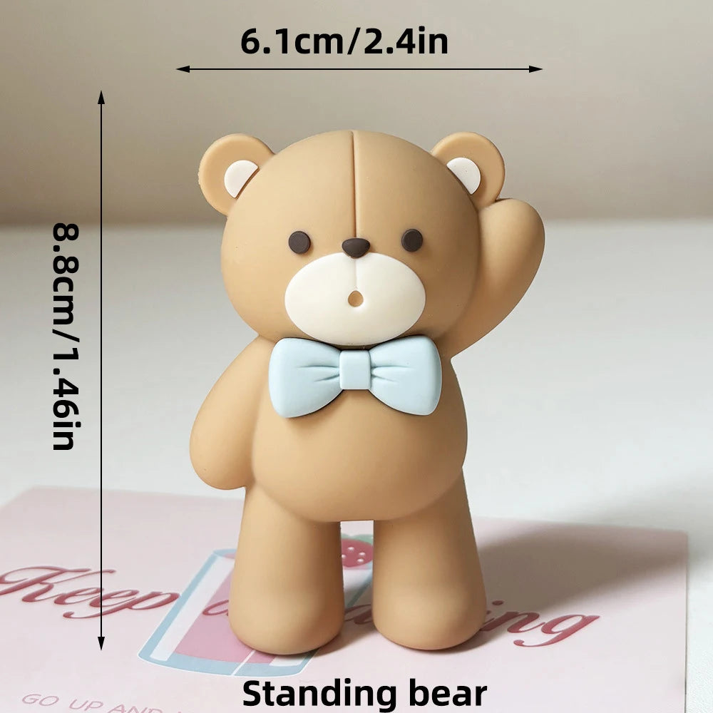 A standing bear figure with a bow, measuring 8.8cm tall and 6.1cm wide.