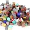 A collection of diverse magnetic building blocks in various colors and textures arranged on a white surface.