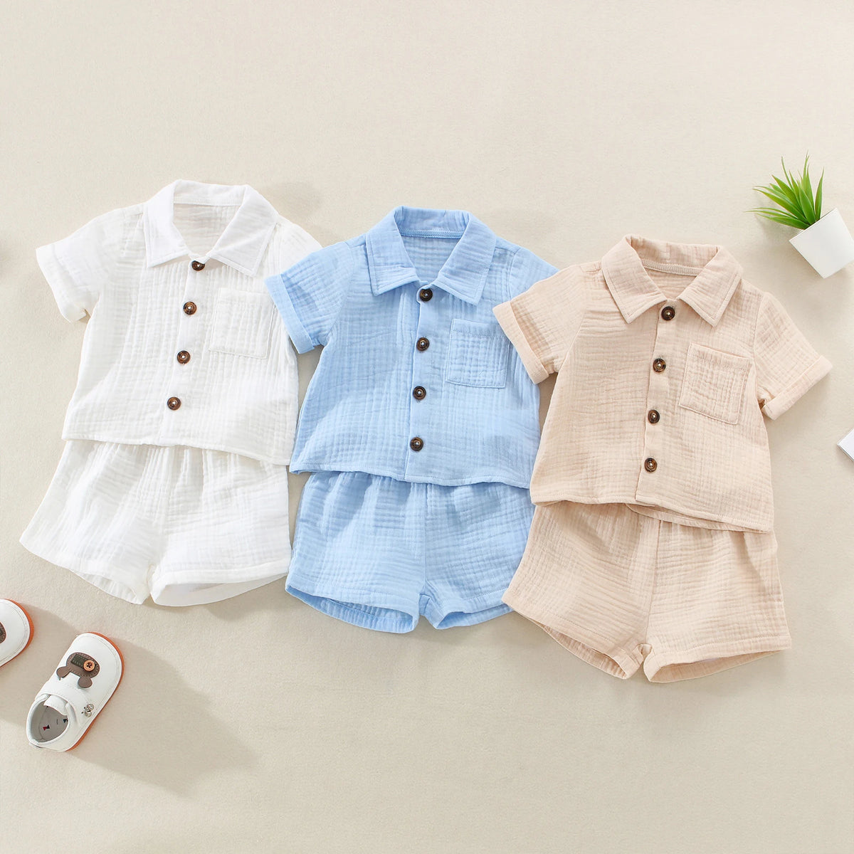A set of baby boy cotton linen summer shirt and shorts in white, light blue, and beige tones.