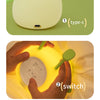 Three views of a soft yellow pear-shaped night light showing its type-c port, switch, and head design.