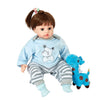 A baby doll wearing a light blue animal romper set with gray striped pants and blue shoes.