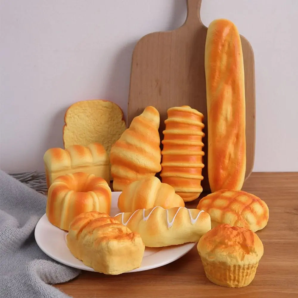 A collection of realistic bread squeeze toys in various shapes and colors resting on a wooden surface.