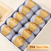 Box of Merino wool yarn balls with yellow labels for knitting and crafting