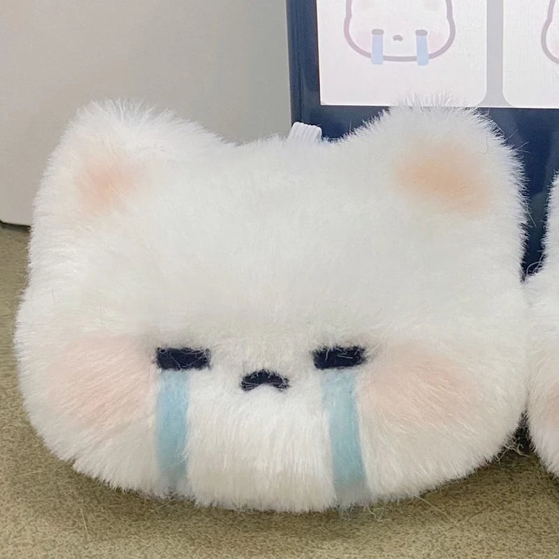 A fluffy white and pink plush rabbit charm with blue tear lines.