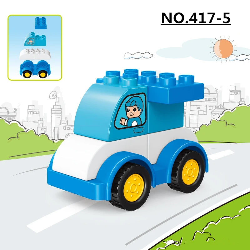 A blue and white construction vehicle building block set is shown driving on a road with green scenery.