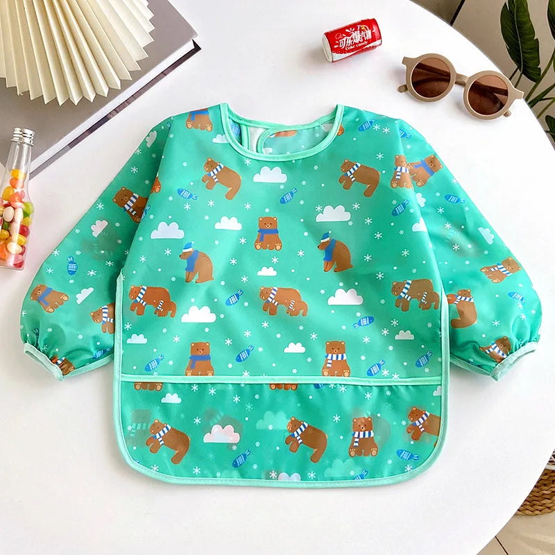 A green full-sleeve waterproof baby bib featuring a cartoon design of bears and clouds.