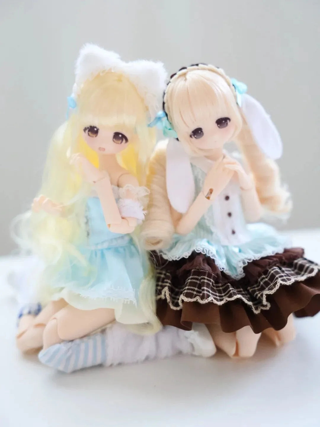 A pair of Guardian Xiangxiang collectible figures, one blonde and one light brown, in a blind box packaging.