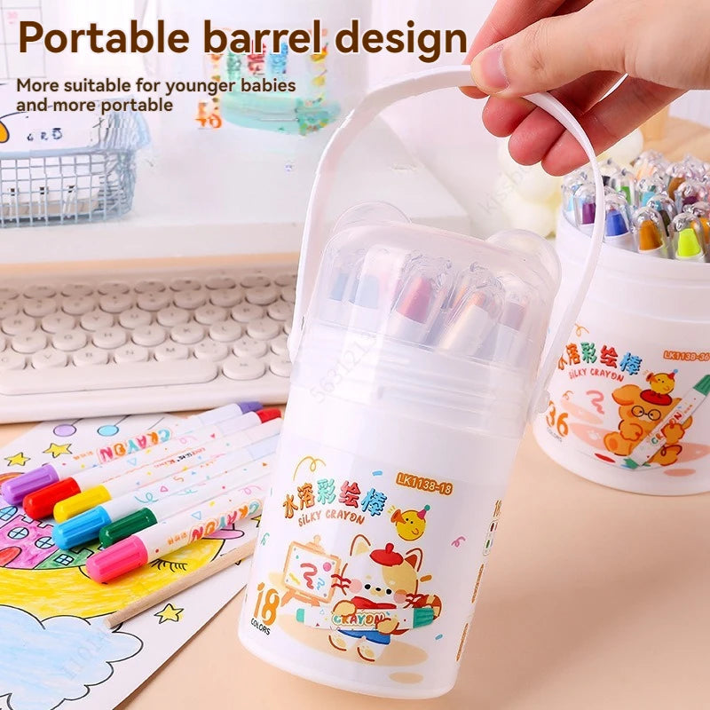 A hand holds a portable barrel design of silky crayon pens with colorful illustrations for children.