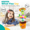 A smiling young girl is interacting with an interactive talking cactus toy that has colorful elements and a pot.