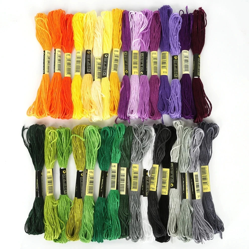 A collection of multicolor embroidery floss skeins in various shades including orange, yellow, purple, and green.