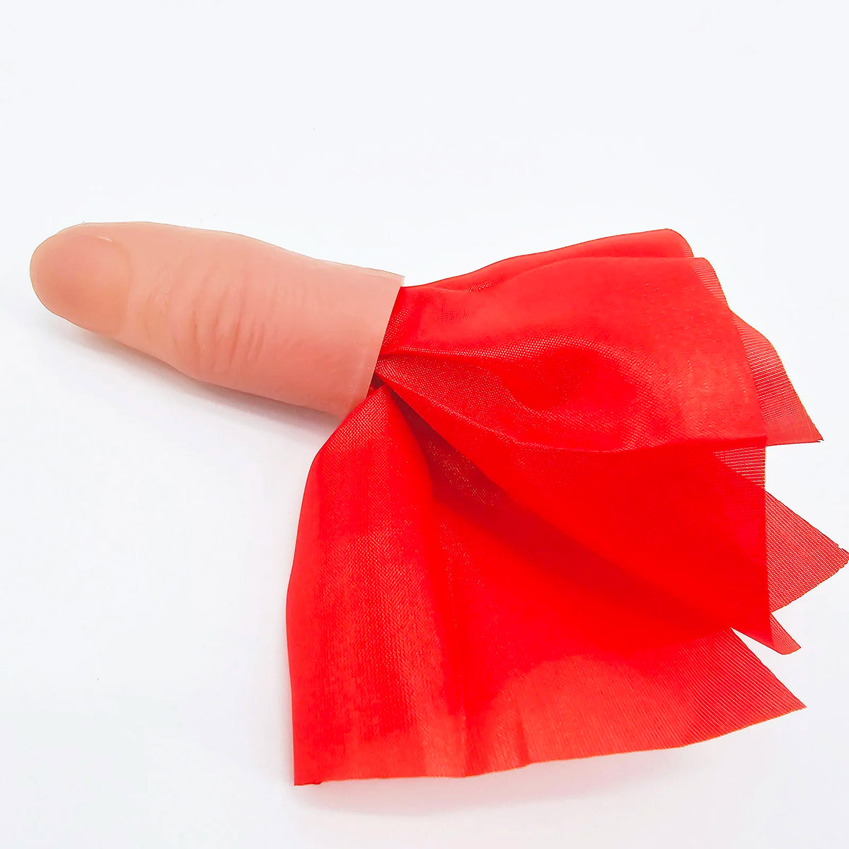 Une main tenant un tissu de soie rouge utilisé comme accessoire pour un tour de magie au doigt.