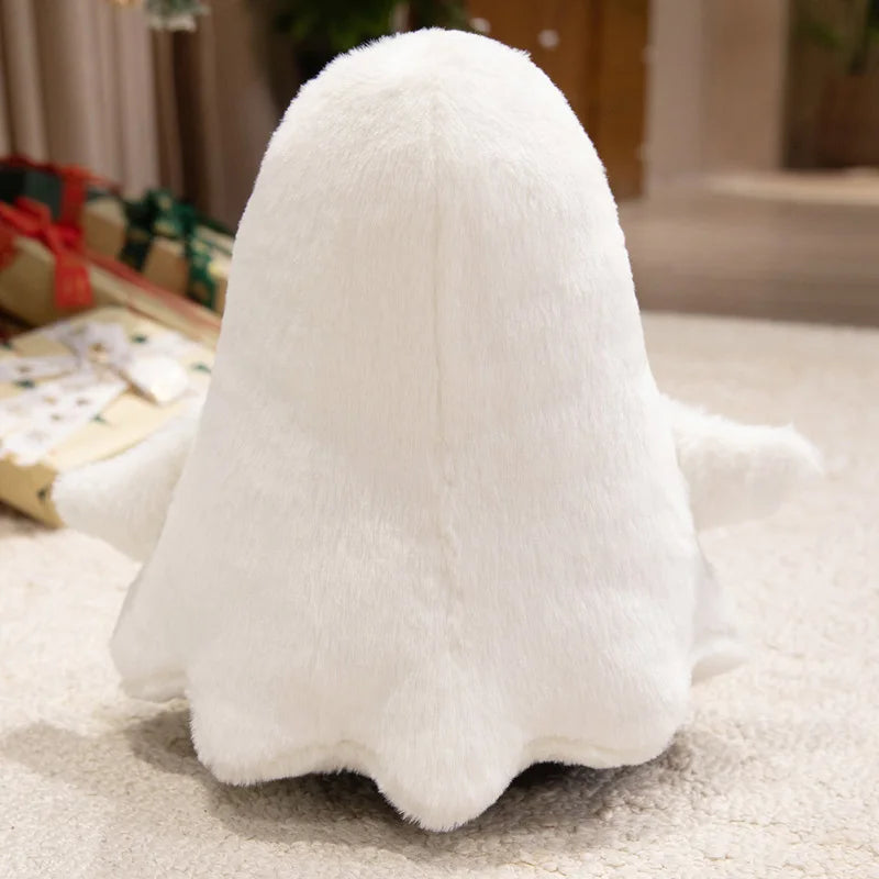 A white ghost plush toy with a rounded body and small arms is resting on a light-colored surface.