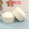 Two white yogurt cake squishy stress relief toys are shown on a light blue surface.