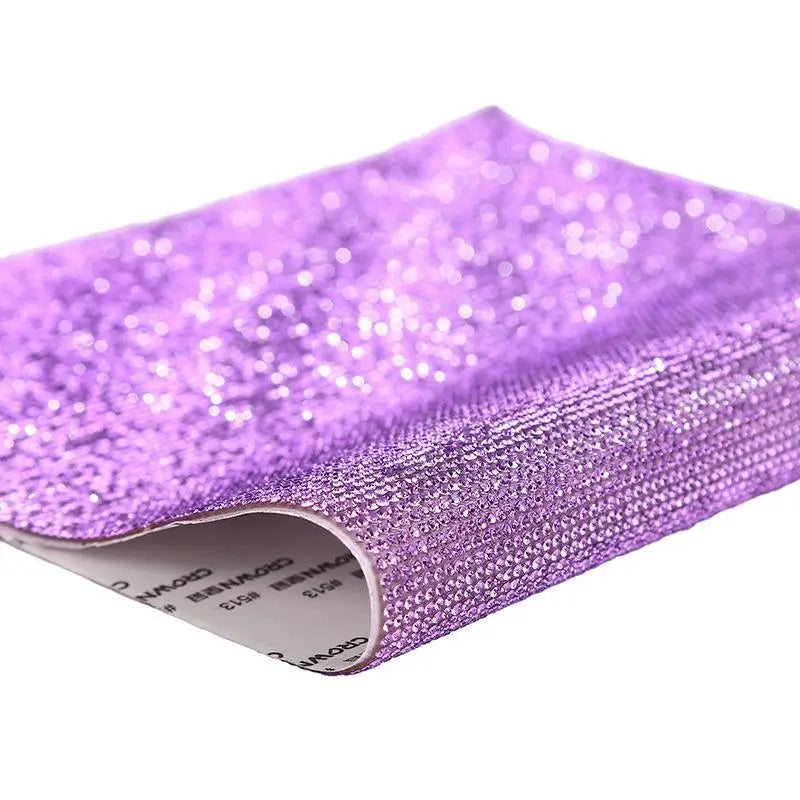 Purple sparkling rhinestone adhesive tape rolled up for DIY crafts and decor