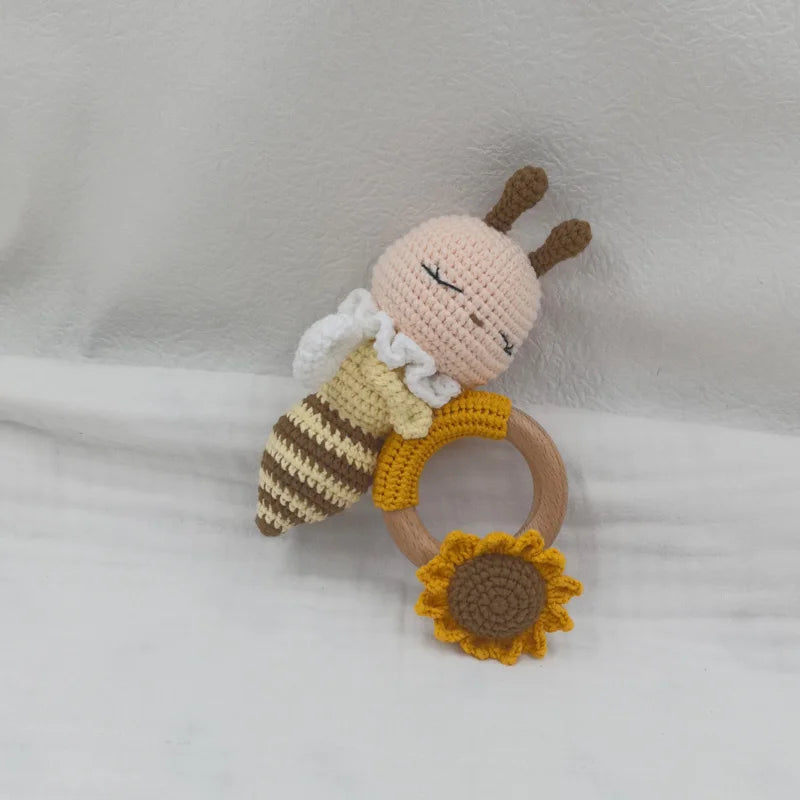 A handmade wooden baby rattle and teether ring shaped like an otter, featuring light beige and yellow tones.