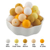 A pile of assorted silicone beads in white, cream yellow, mustard yellow, beige, and bright yellow colors.