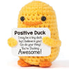 A handmade crochet positive duck doll in yellow with orange accents.