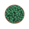 A pile of small, round, green silicone beads in a wooden bowl for jewelry making and crafts.