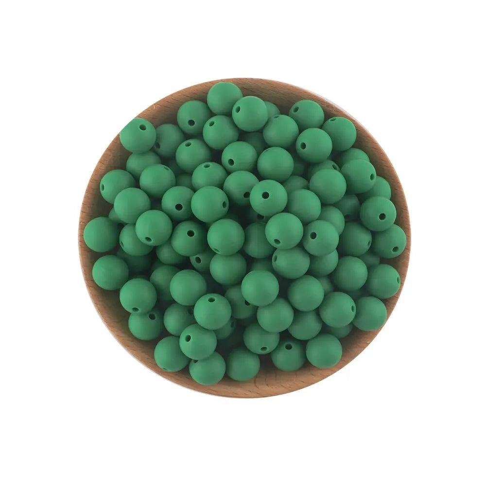 A pile of small, round, green silicone beads in a wooden bowl for jewelry making and crafts.