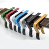 A row of colorful aluminum alloy quick-change guitar capos with black and silver tuning pegs.
