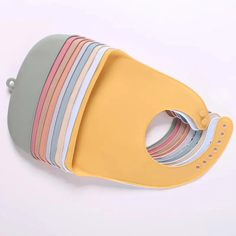 Yellow silicone baby bib with a catch pocket and multiple colored stripes