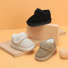 A pair of beige cozy leather winter boots for toddlers with anti-slip rubber soles displayed on a wooden surface.