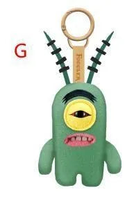 A green plush monster keychain with a rabbit face design and a gold loop.