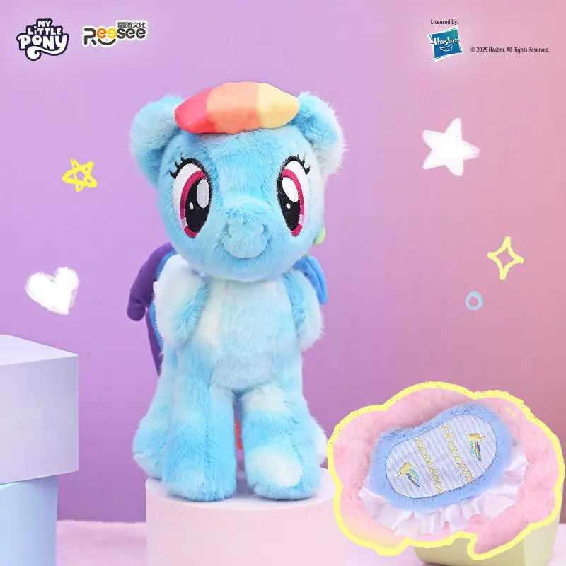 A fluffy light blue My Little Pony plush toy with a pink mane and a purple saddle accessory.