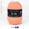 A ball of soft peach colored milk cotton yarn labeled 03# 浅橙, ready for knitting or crochet.